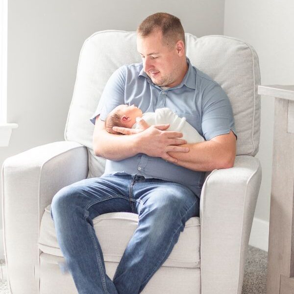dad holding baby in chair