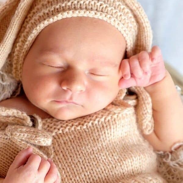 sleeping newborn in knit outfit